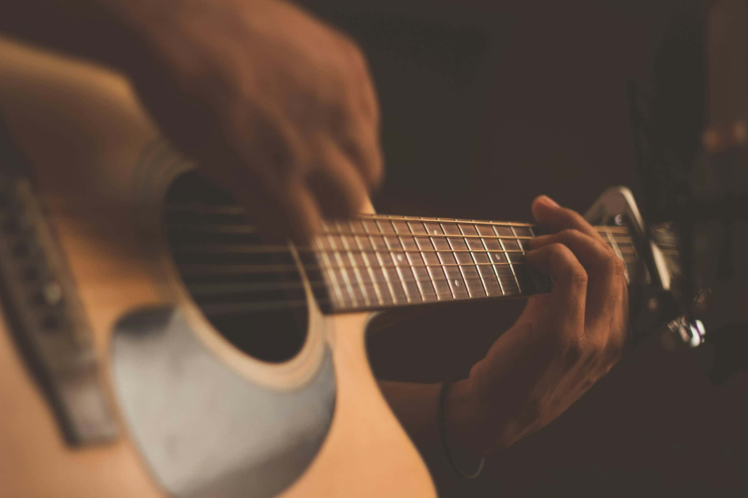 Close-up of hands playing an acoustic guitar