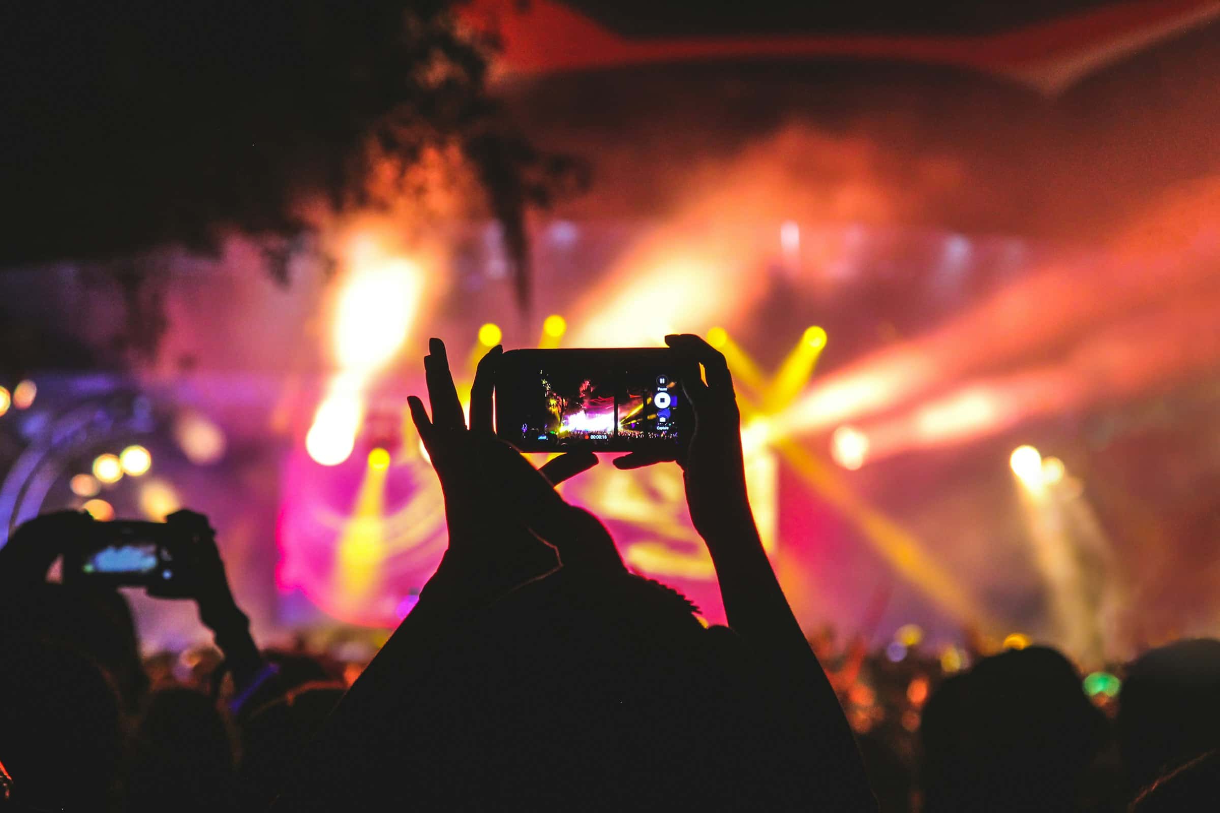 A fan filming a concert on a phone