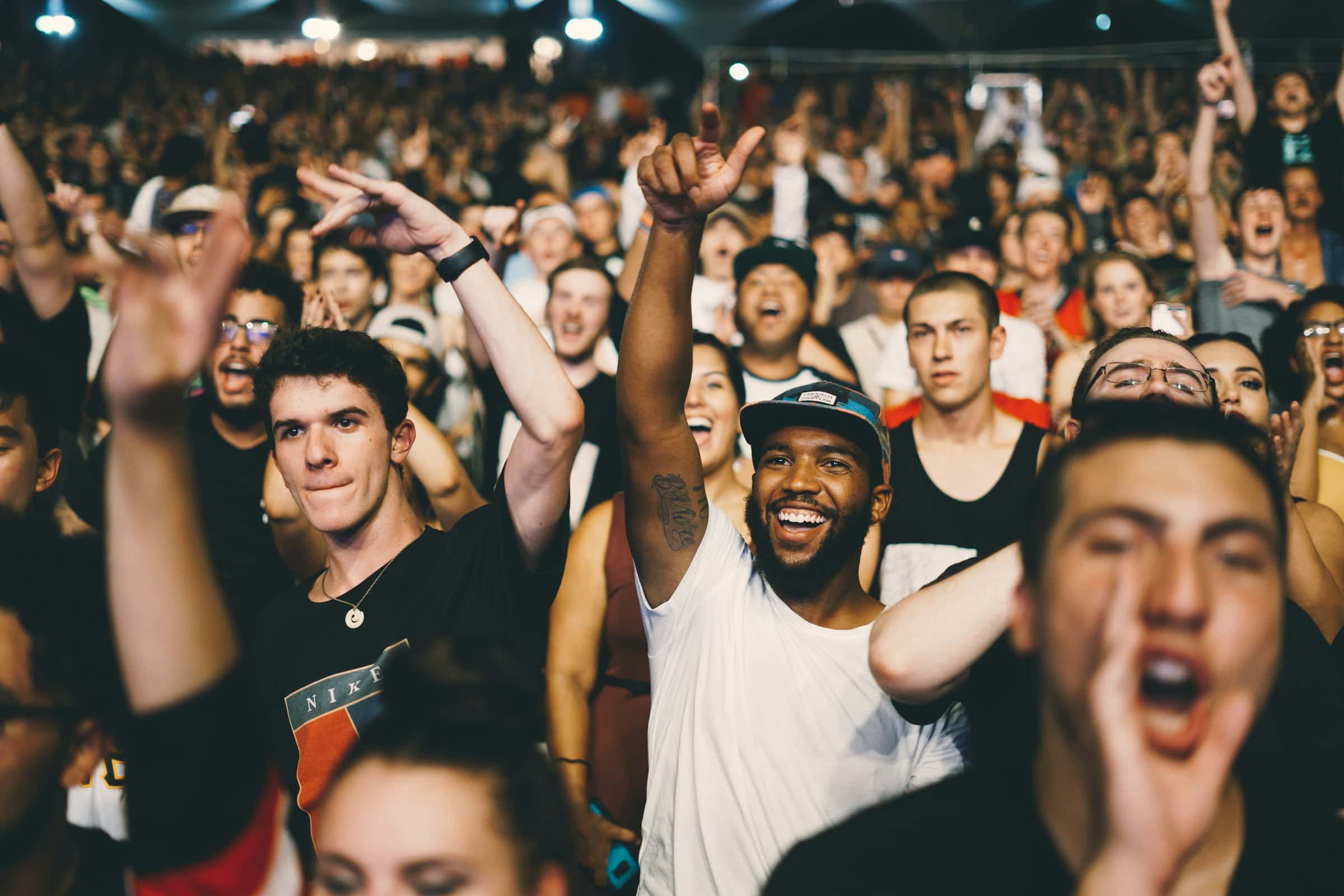 An excited crowd cheering at a concert