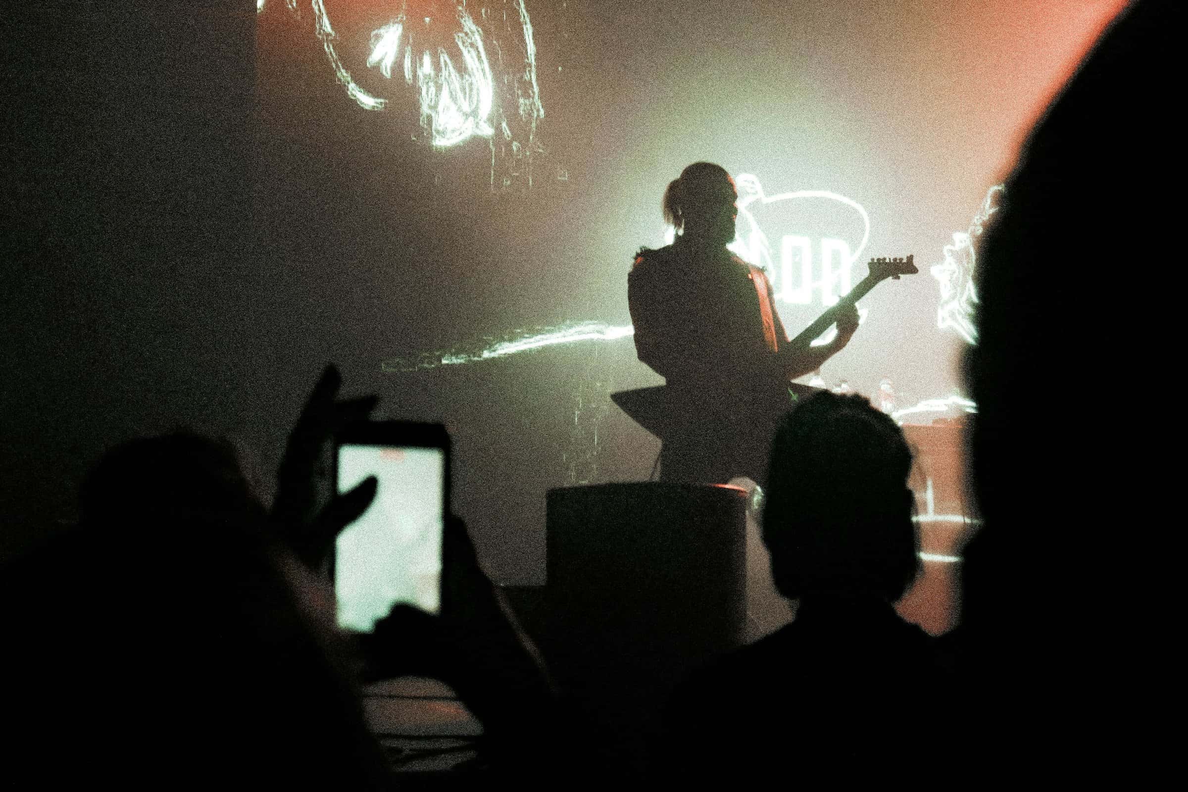 A phone held up to film a performer on stage